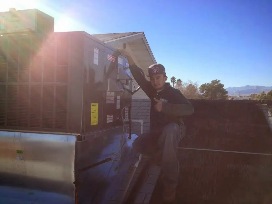 HVAC technician performing Air Duct Cleaning on a rooftop unit in Stickney